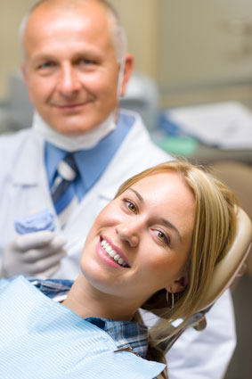 A woman and her dentist smiling